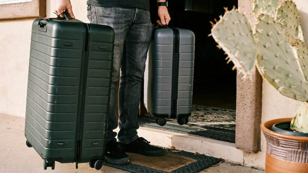 A man holding two heavy suitcases