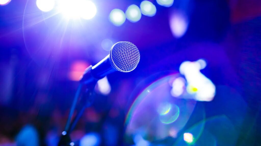 I Tried AI to Improve My Public Speaking Skills. It Didn’t Listen That Well Photo of a microphone against a purple neon background gettyimages-1026472960