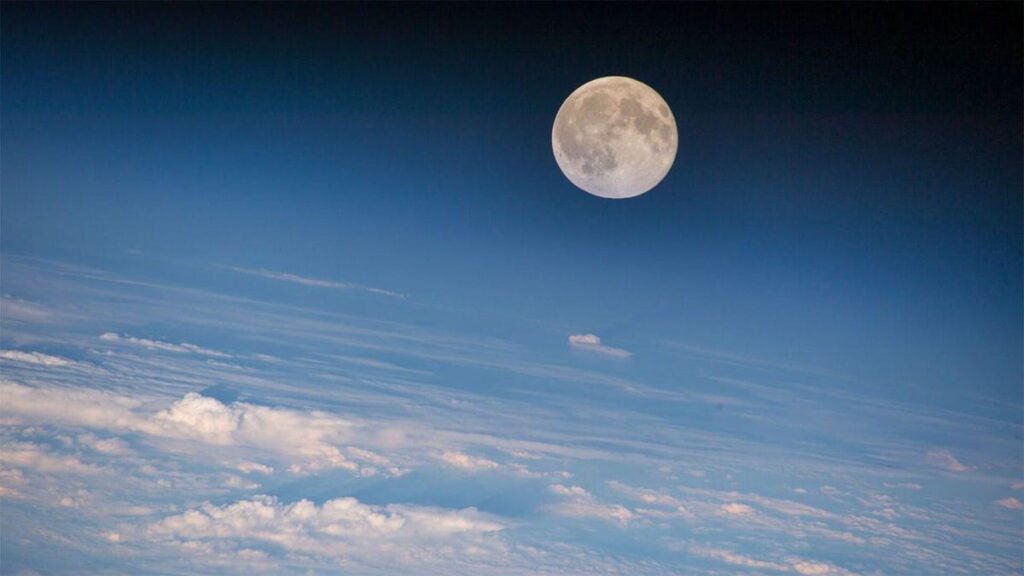A full moon in the sky with clouds