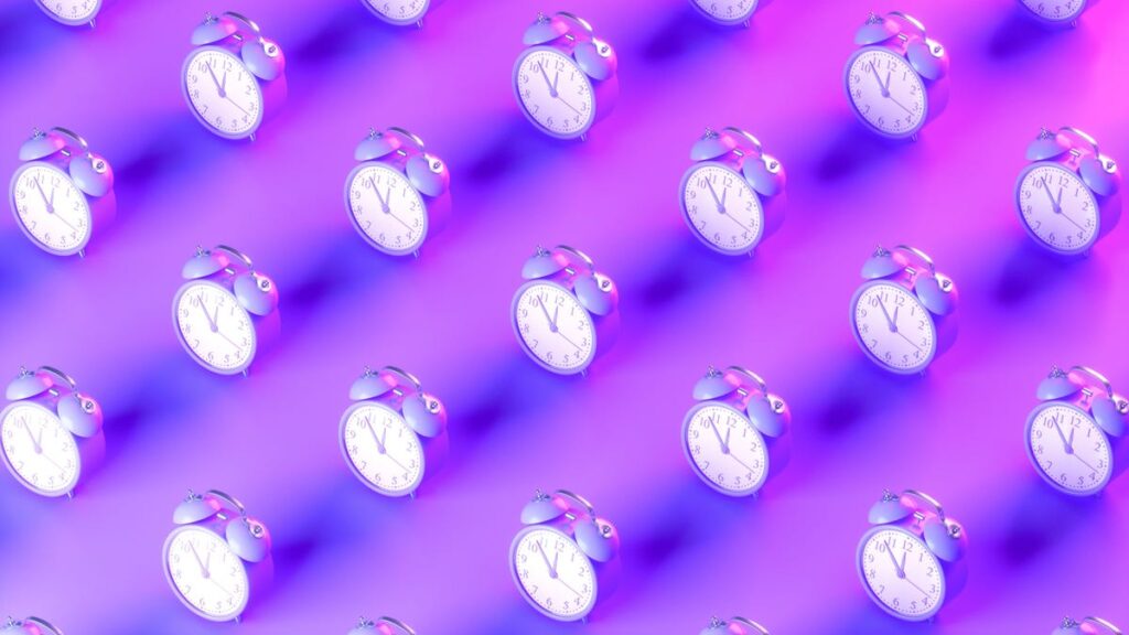 An image of alarm clocks on a neon purple background gettyimages-1424866730