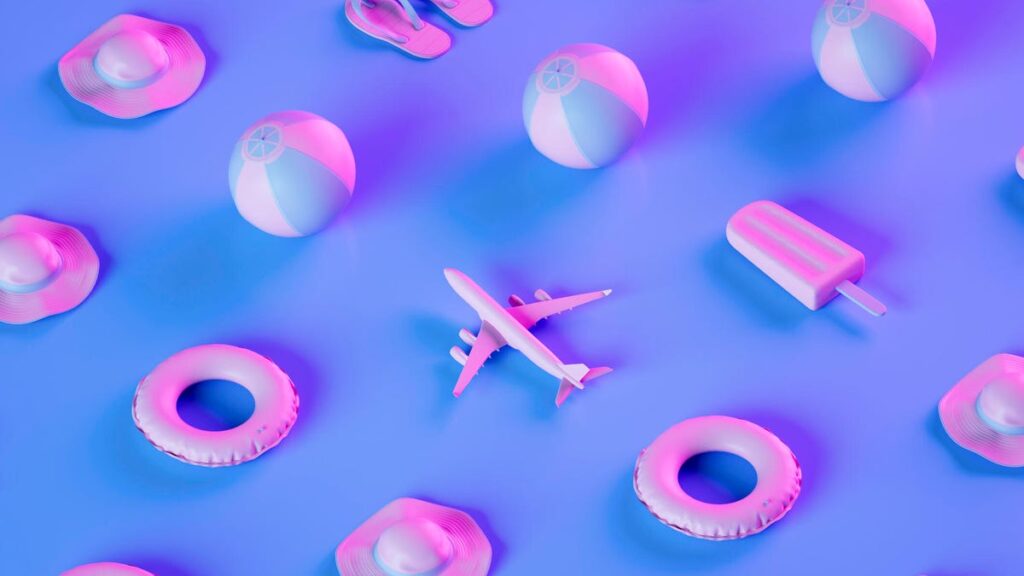 An image of planes, beach balls, flotation rings, popsicles and flip flops on a purple and pink background gettyimages-1486013518