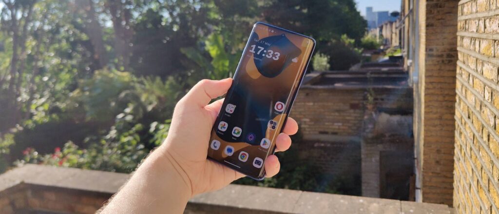 The Motorola Edge 60 Pro above a leafy garden