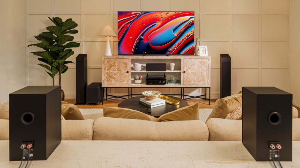 A pair of Sony SS-CS3M2 behind a beige sofa in a brightly light room. There is a Sony TV at the other end of the room with more SS speakers beside and below it, as well as a Sony AV receiver.