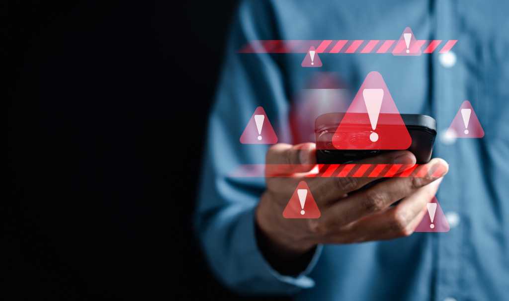 Discovery of compromised Shellter security tool raises disclosure debate System warning caution sign on smartphone, scam virus attack on firewall for notification error and maintenance. Network security vulnerability, data breach, illegal connection and information danger.