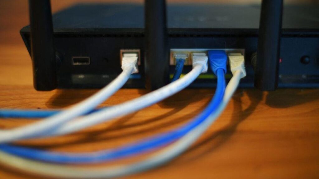 the back of a router with five Ethernet cables plugged in