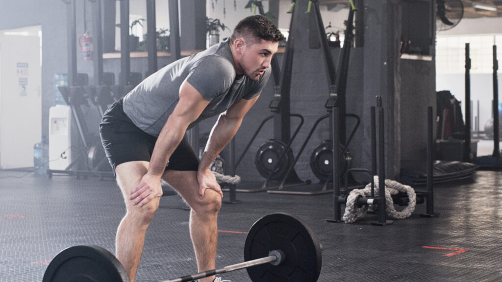 A man taking a rest period in between his sets at the gym