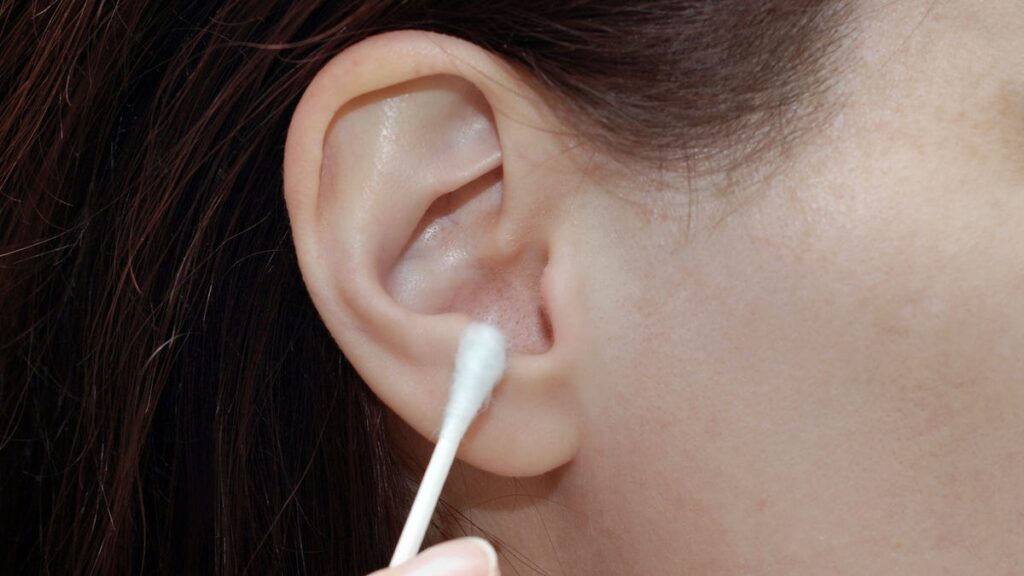 Put Down the Q-Tips. This Is the Right Way to Clean Your Ears A cotton swab on an ear.