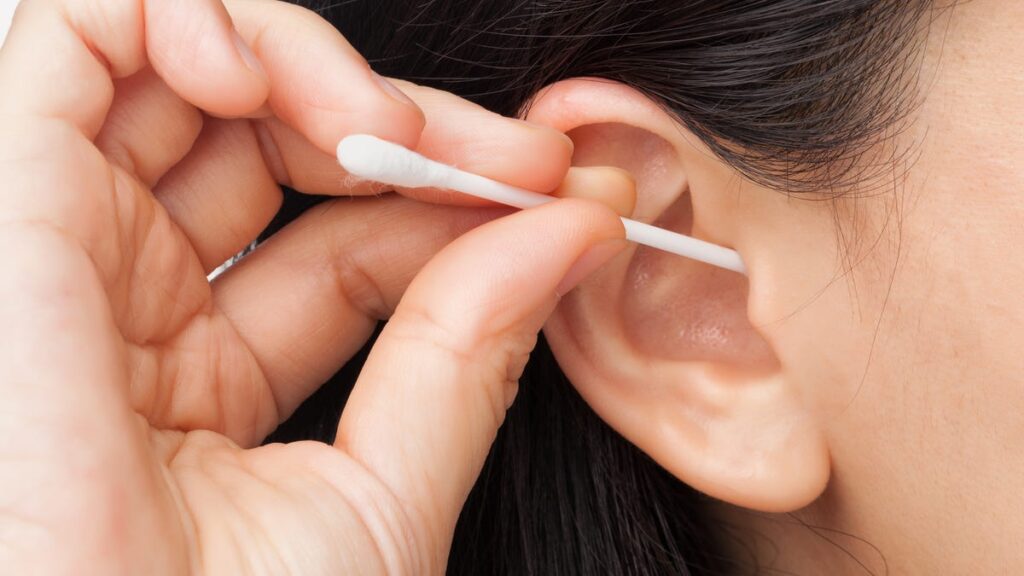 A cotton swab on an ear.