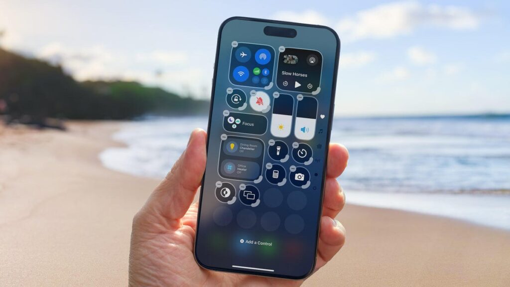 Change These 10 iOS 18.6 Settings Now and It’ll Feel Like You Got a New iPhone A hand holds an iPhone in front of a warm fireplace.