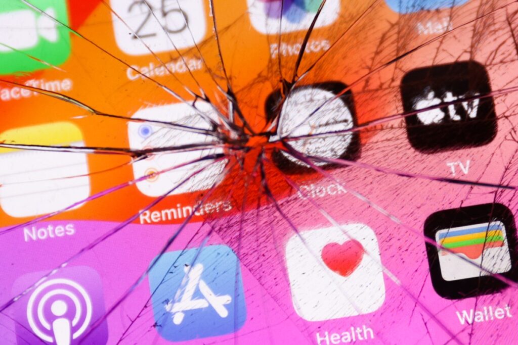 New zero-day startup offers $20 million for tools that can hack any smartphone App icons displayed on a phone screen are seen through the broken glass in this illustration photo.