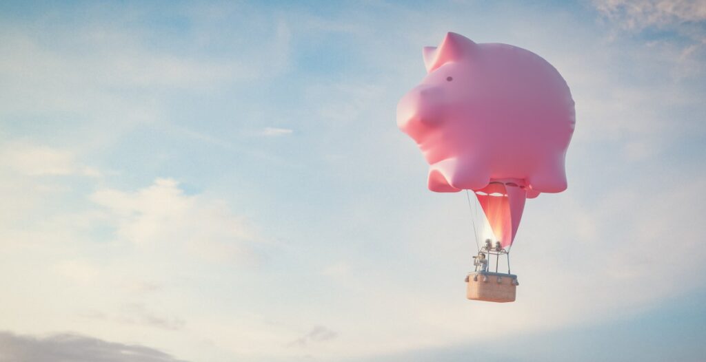 A pink piggy bank as a hot air balloon
