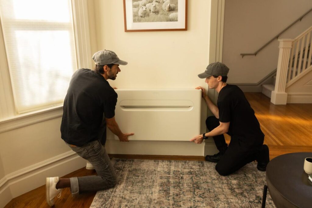 Why a former AirPods engineer is now building heat pumps Two men install a heat pump on a wall.